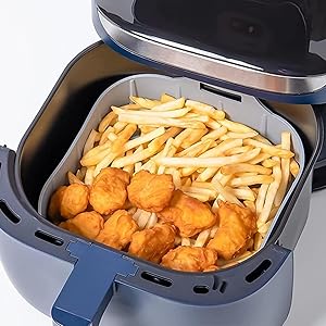batatas palito e nuggets dentro da forma de silicone em uso dentro do cesto da air fryer